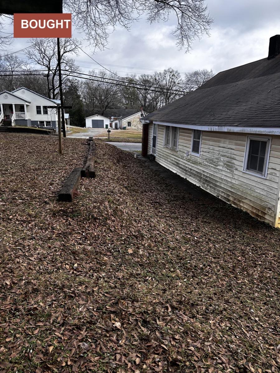 The side of a weathered single-family home previously purchased by Shades Creek Home Buyers.